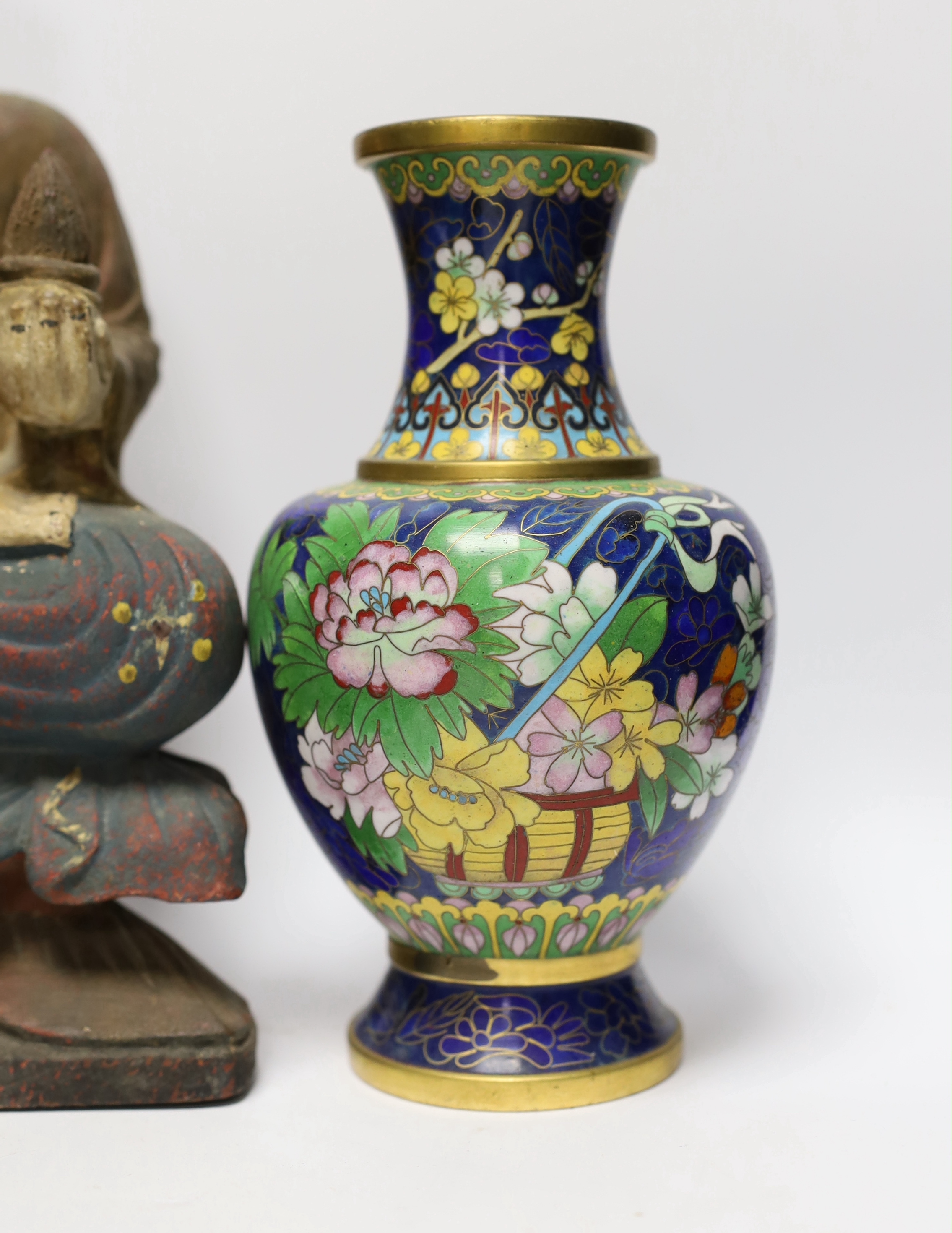 A pair of Chinese cloisonné enamel vases and a bowl on stand, two soap stone lion dogs, a carved and painted Buddha, a deity and four wooden stands, Buddha 33cm high